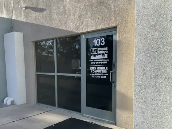 Storefront entrance with glass doors, address 103, sign on the door advertising EMS Mobile Computers and contact numbers.